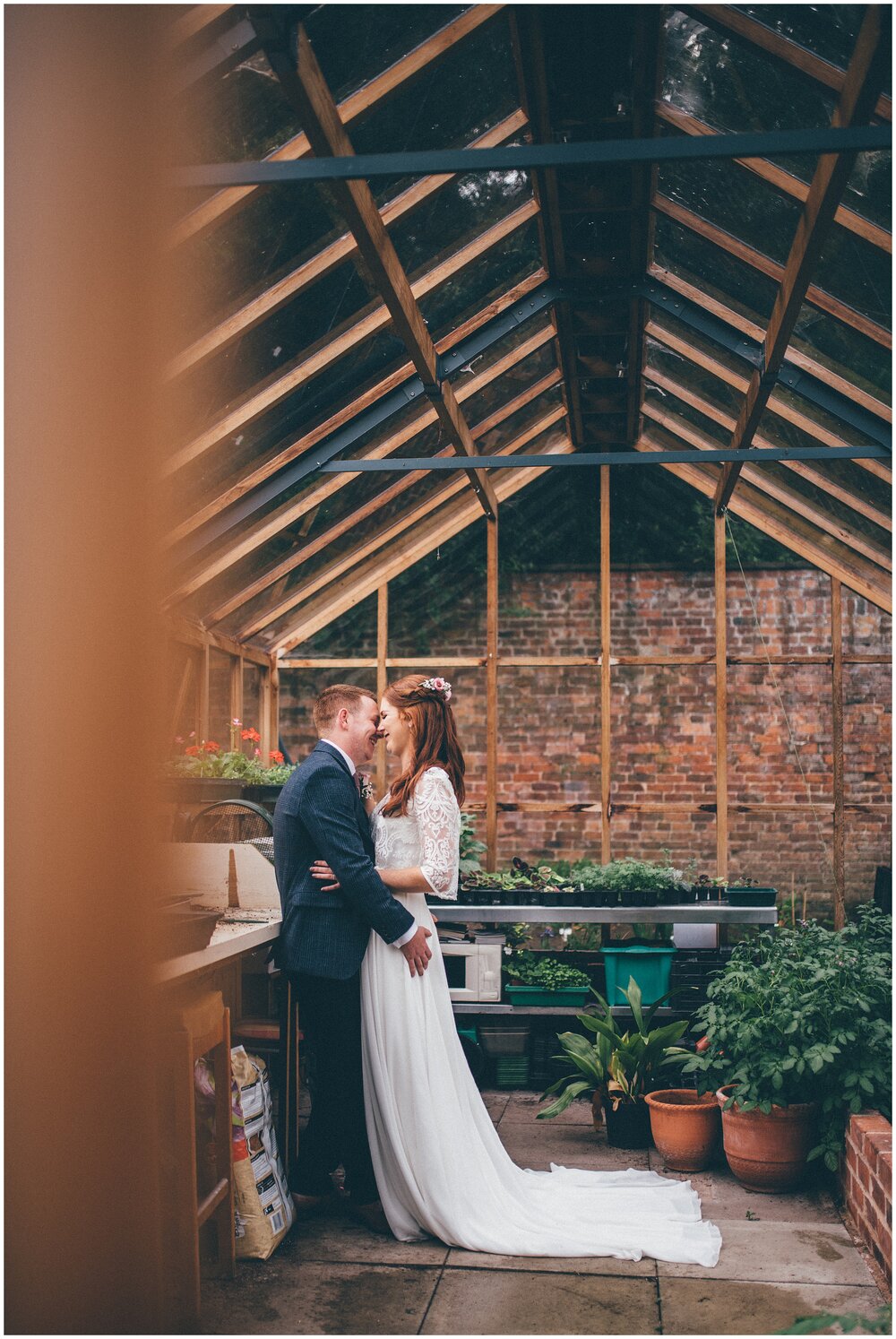 Bride and groom have their wedding photographs taken in a greenhouse at their Cheshire wedding venue.