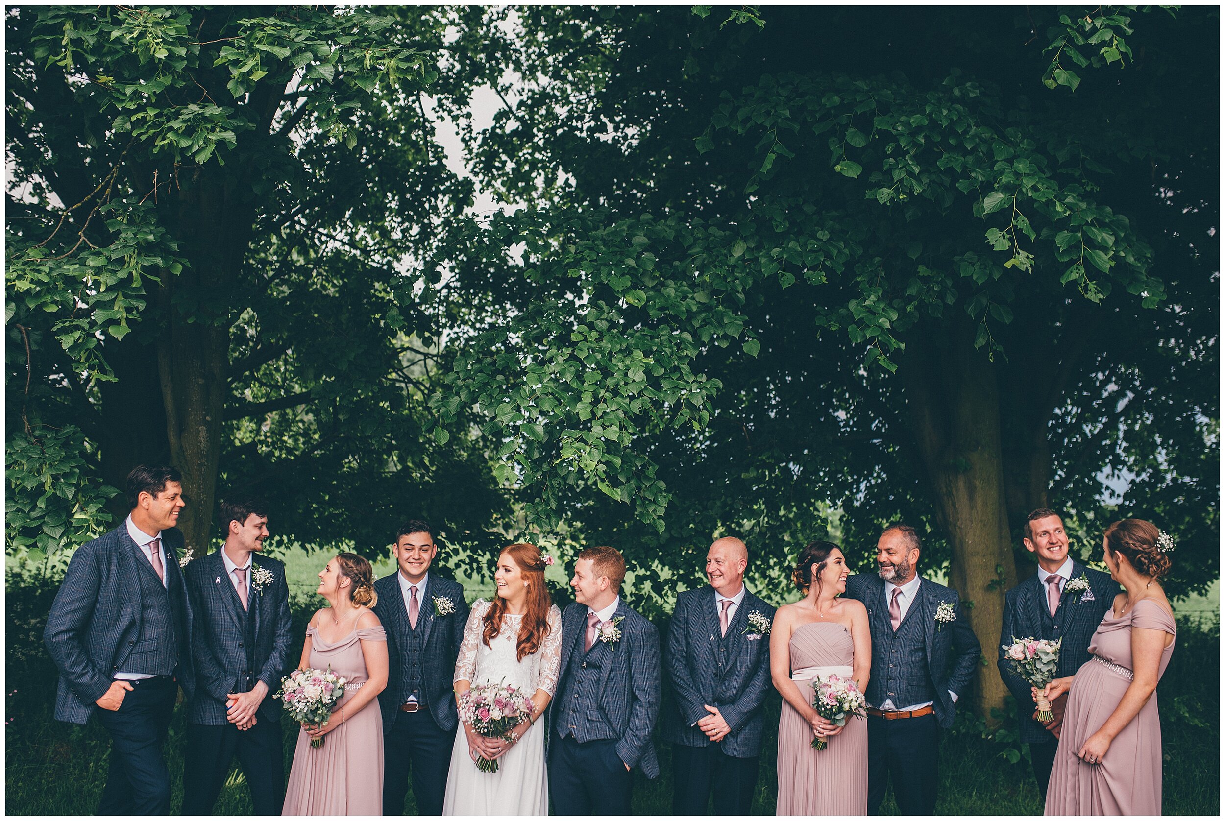 Bride and groom and their bridal party all together during summertime wedding.
