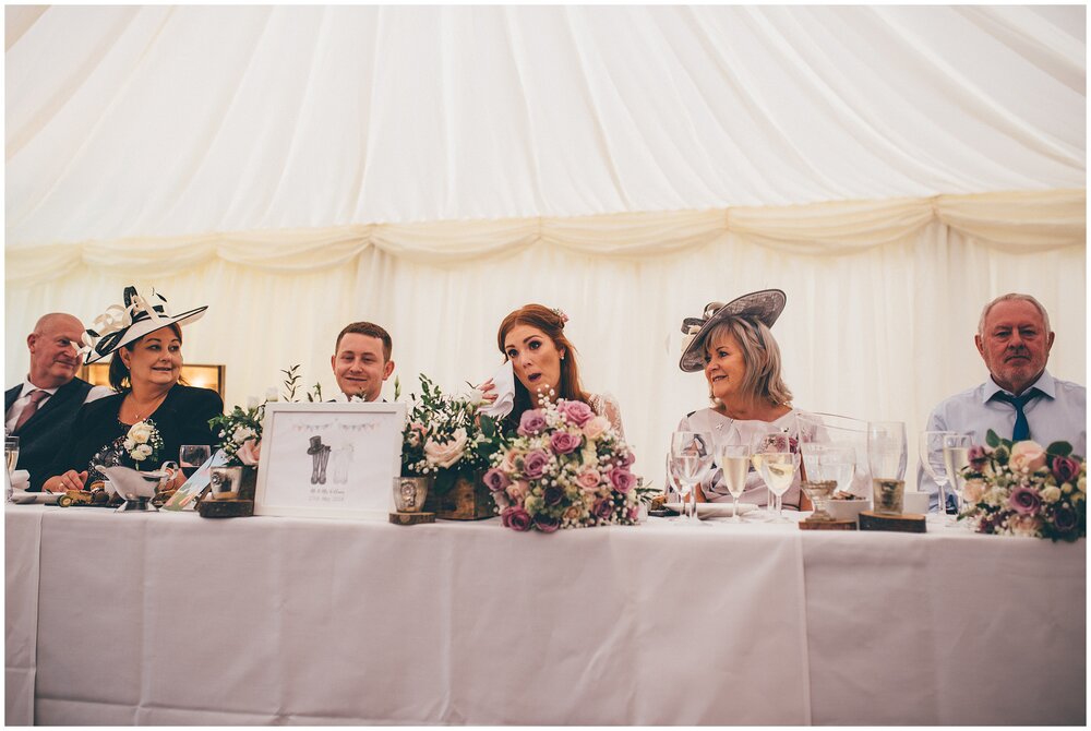 Bride cries during speeches at her festival themed wedding.