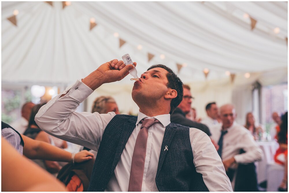 Guests doing shots during festival themed summer wedding in Cheshire.