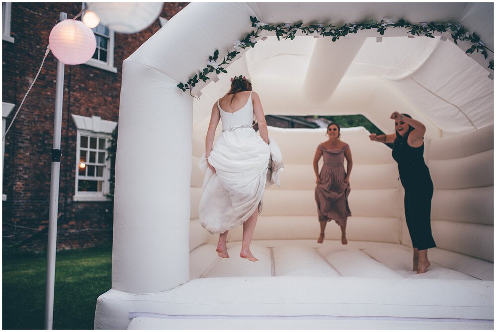 Bride and her friends play on the bouncy castle.