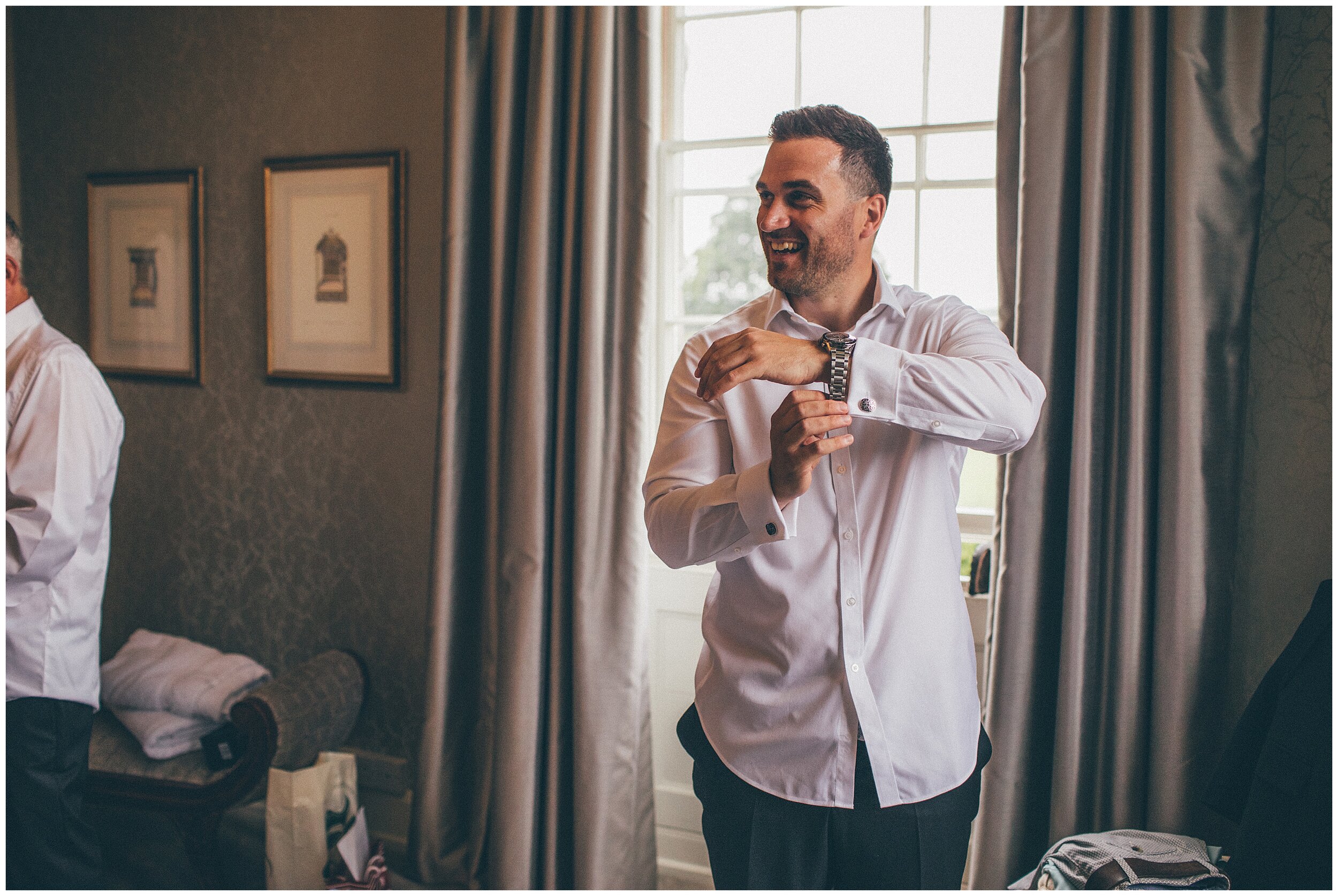 Groom fastens his shirt before his wedding at Hereford wedding venue, Lemore Manor.