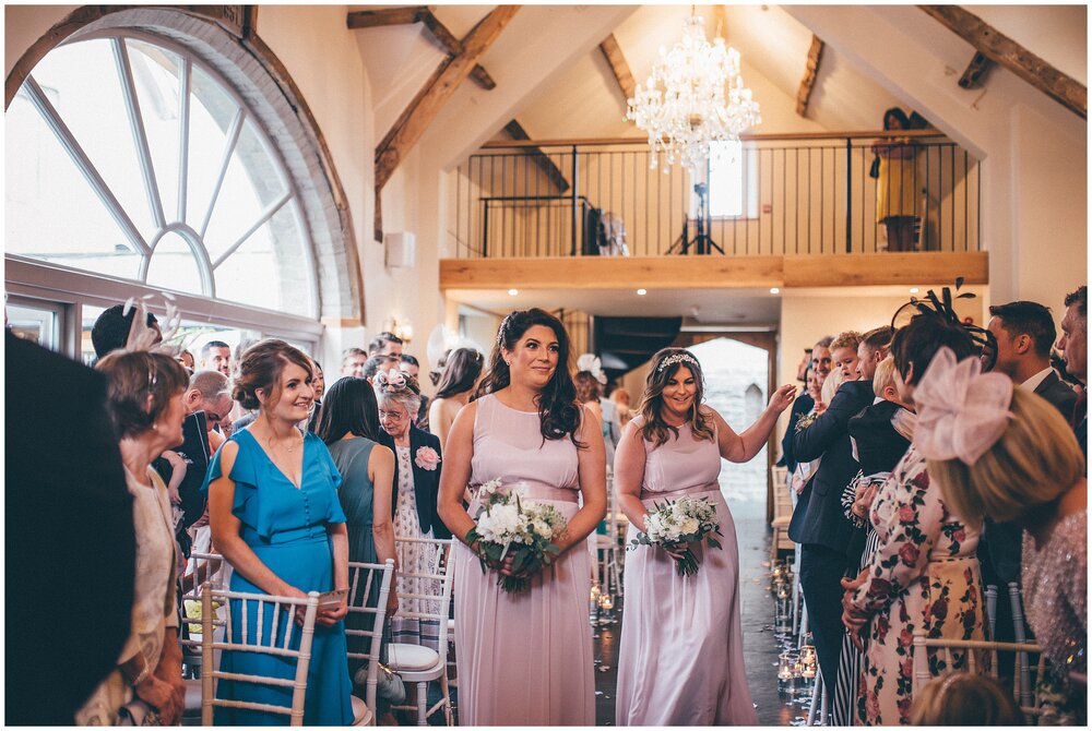 Bridesmaids excitedly walk down the aisle in the beautiful Lemore Manor ceremony room.
