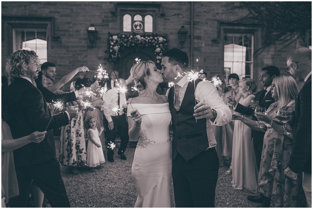 Bride and groom kiss during their sparkler shots at Lemore Manor.
