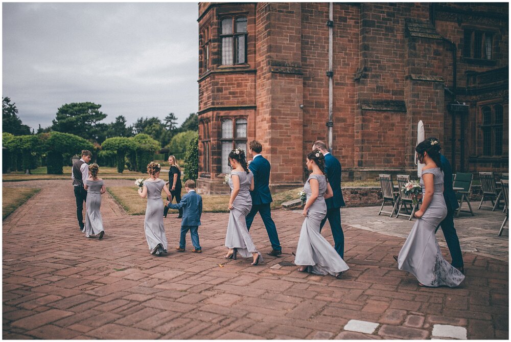 Bridesmaids and groomsmen walk into Thornton Manor for the wedding.