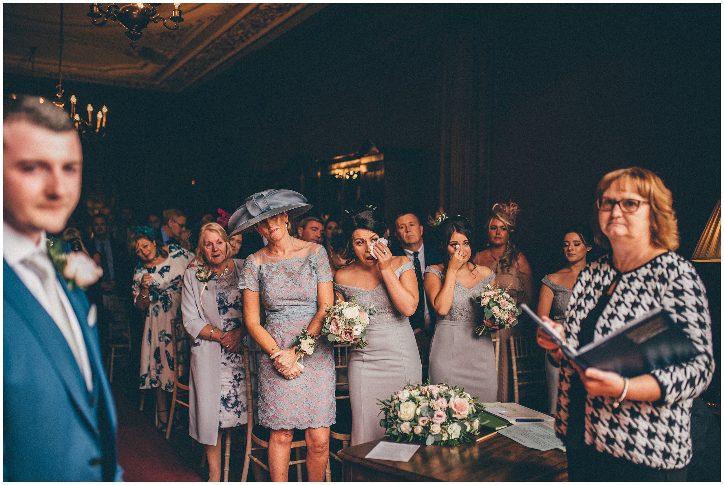 Bridesmaids all watch the bride walk towards her groom at Thornton Manor.