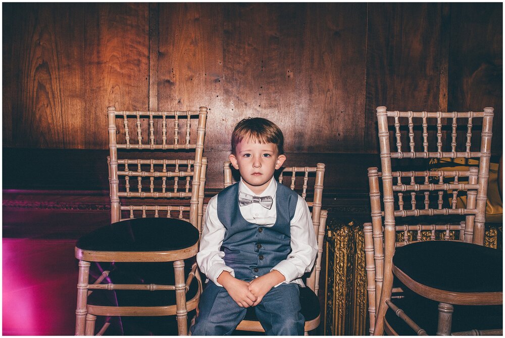 Cute pageboy is tired in the wedding reception at Thornton Manor.