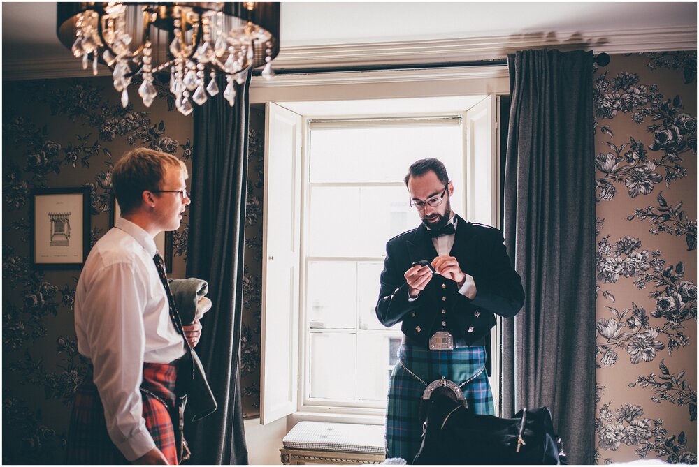 Groom and his best man get ready and get their kilts on.