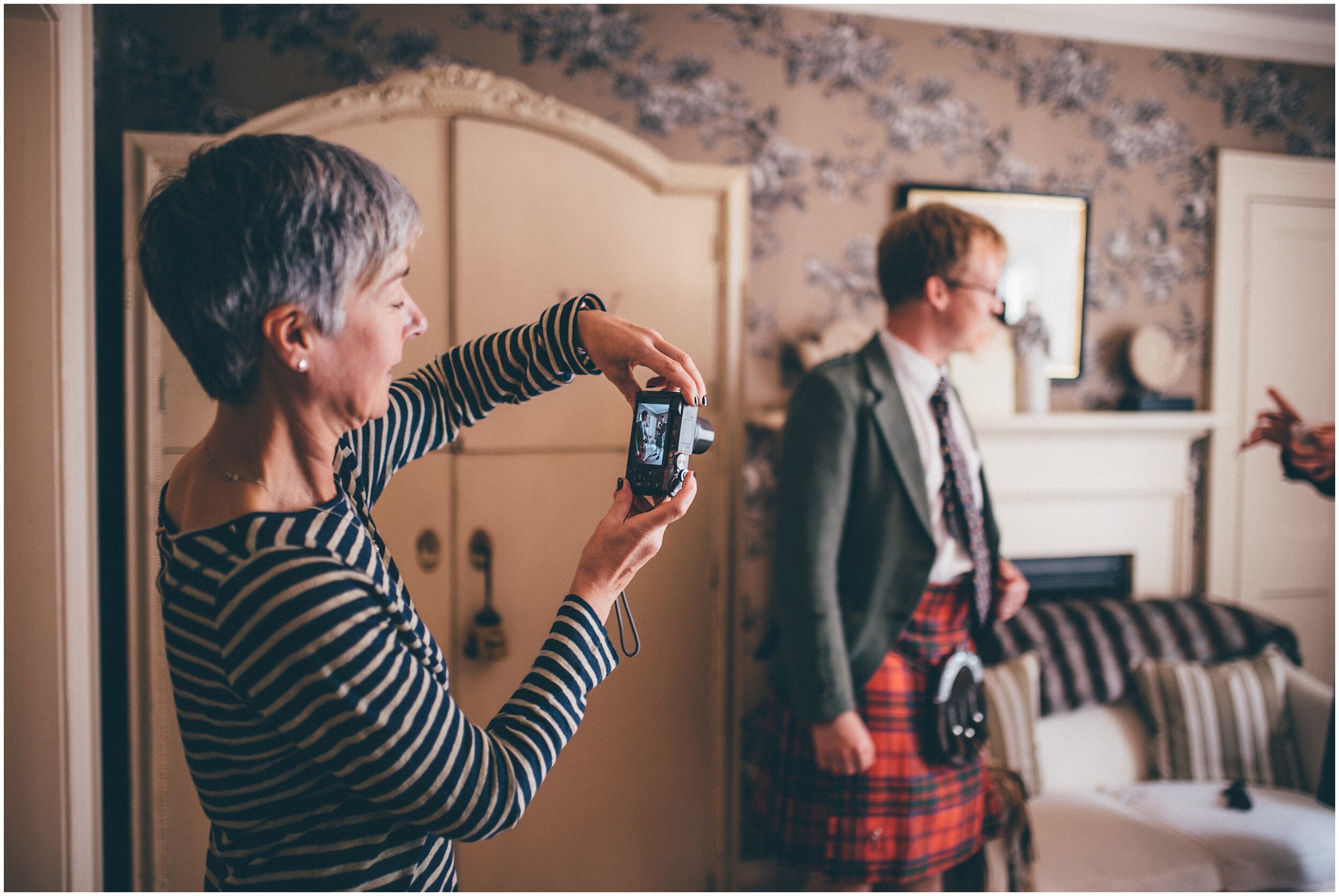 Grooms mum takes photographs of her son in his kilt on the morning of his Scottish wedding.