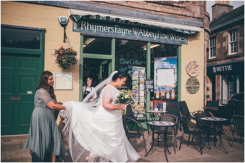 Bride walks through the town of Melrose on the way to her wedding.