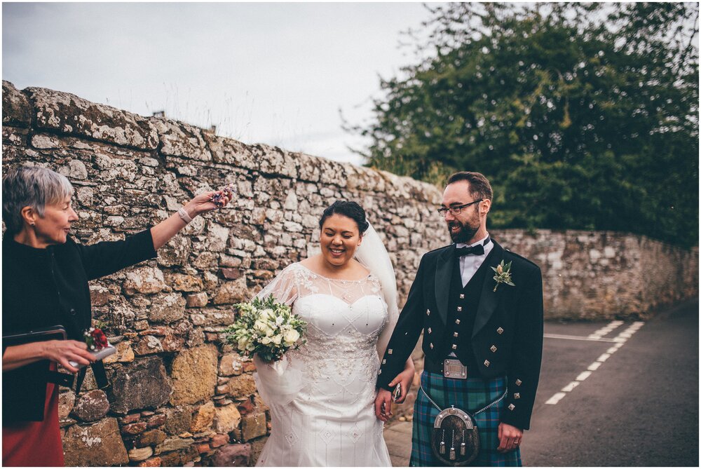 Bride and groom get confetti thrown over them in Melrose after their Melrose Abbey wedding.
