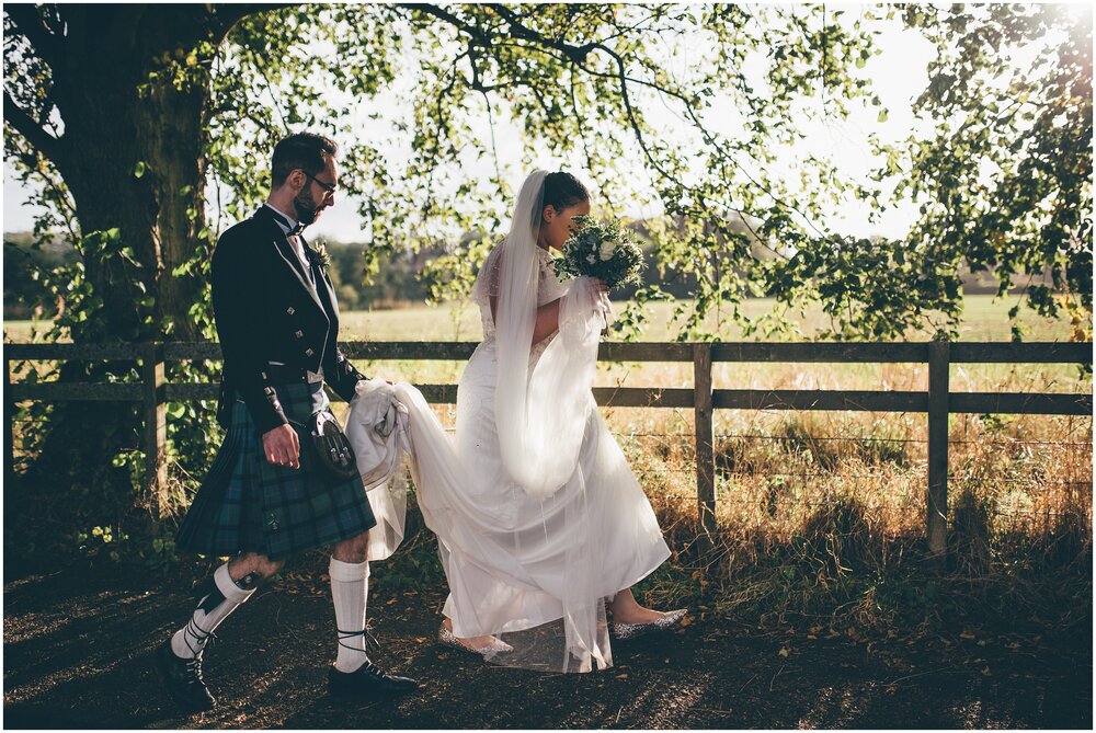 Bride and groom walk to their wedding reception through Melrose following a bagpipe player.