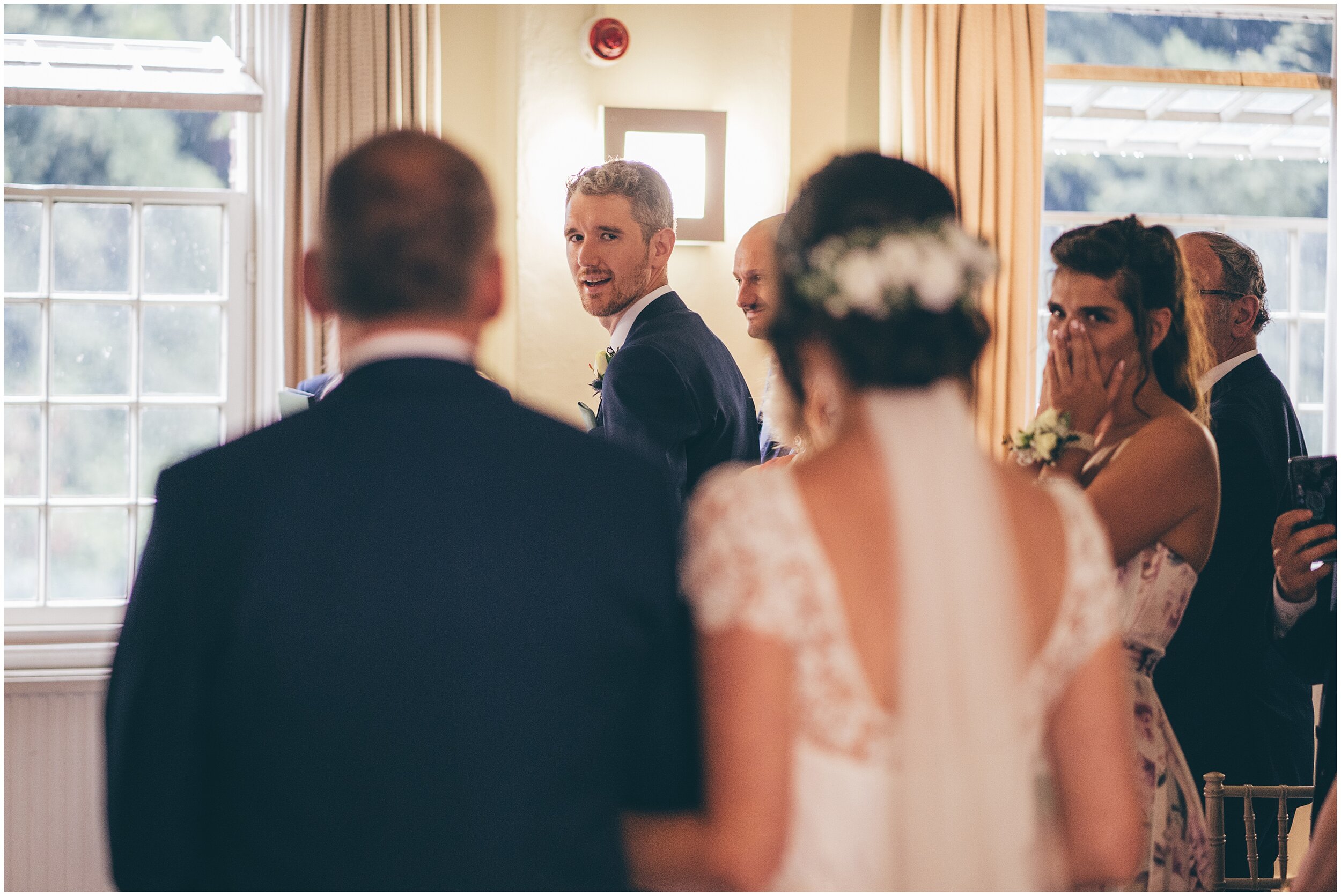 Groom looks back to his bride at Quarry Bank Mill wedding in Cheshire near to Manchester.