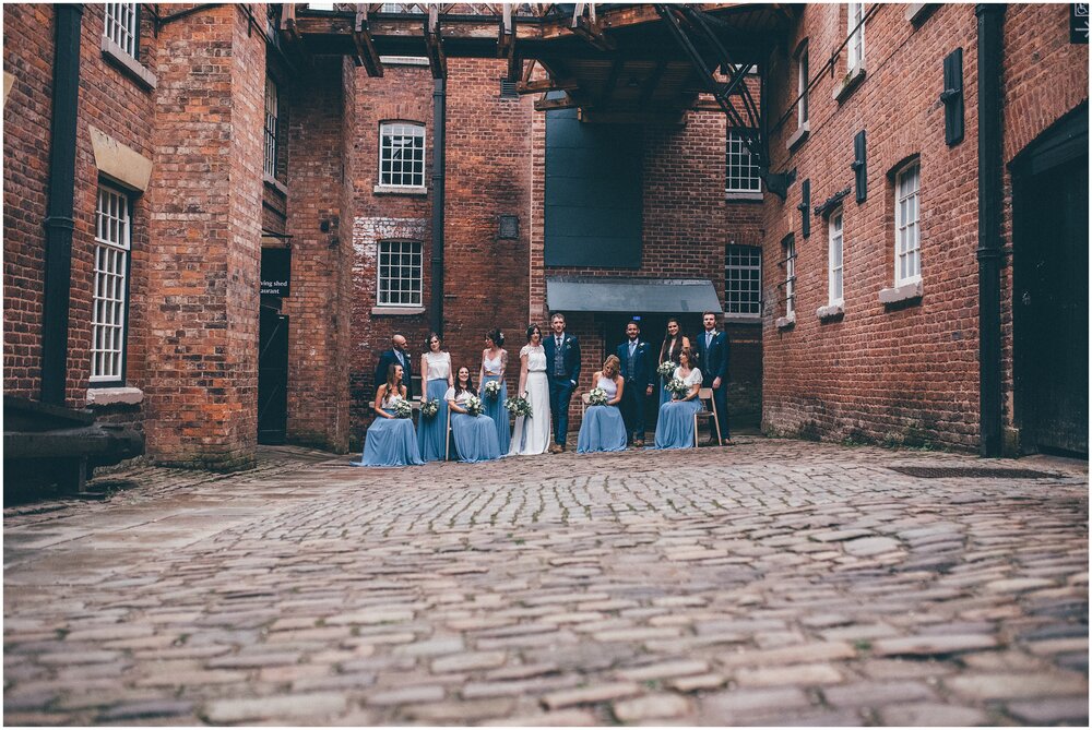 Whole bridal party outside in the courtyard at Quarry Bank Mill wedding in Cheshire near to Manchester.