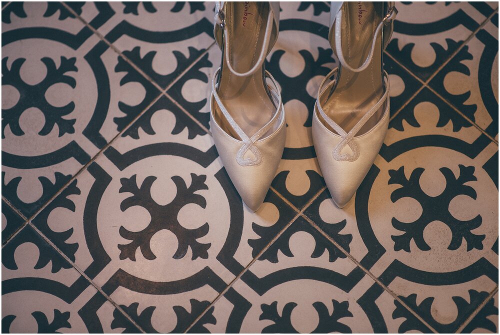Bride's shoes on the black and whit tiled floor at wedding venue.