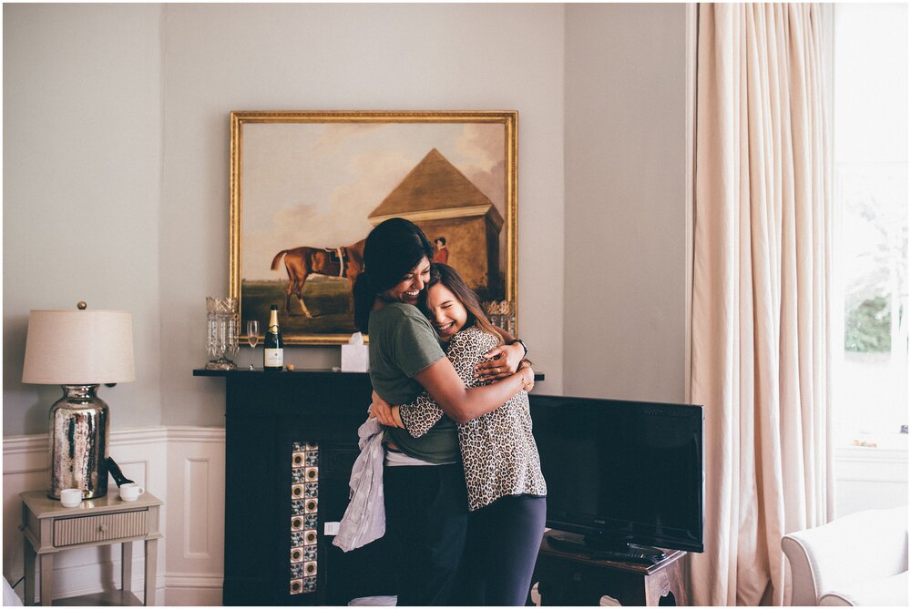 Two bridesmaids have a cute cuddle before the wedding.