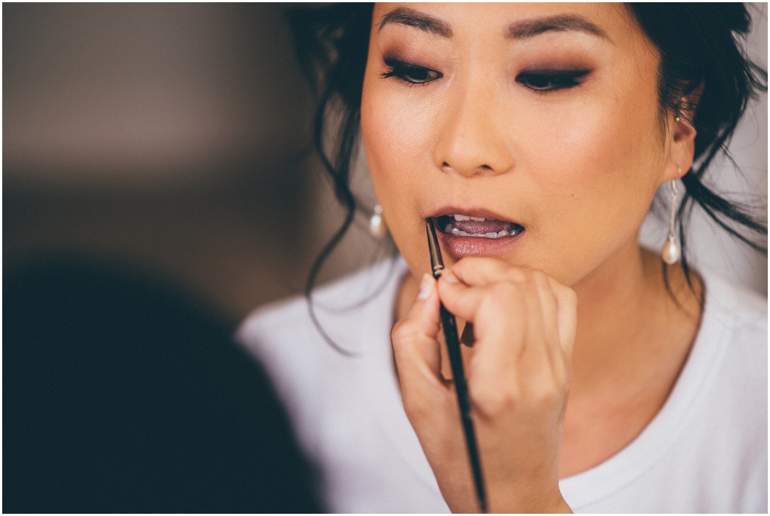 Beautiful bride gets her makeup professionally done.