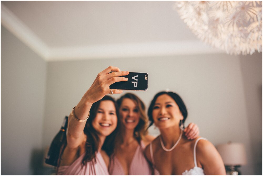 Bridesmaids and the bride take a selfie before the wedding.