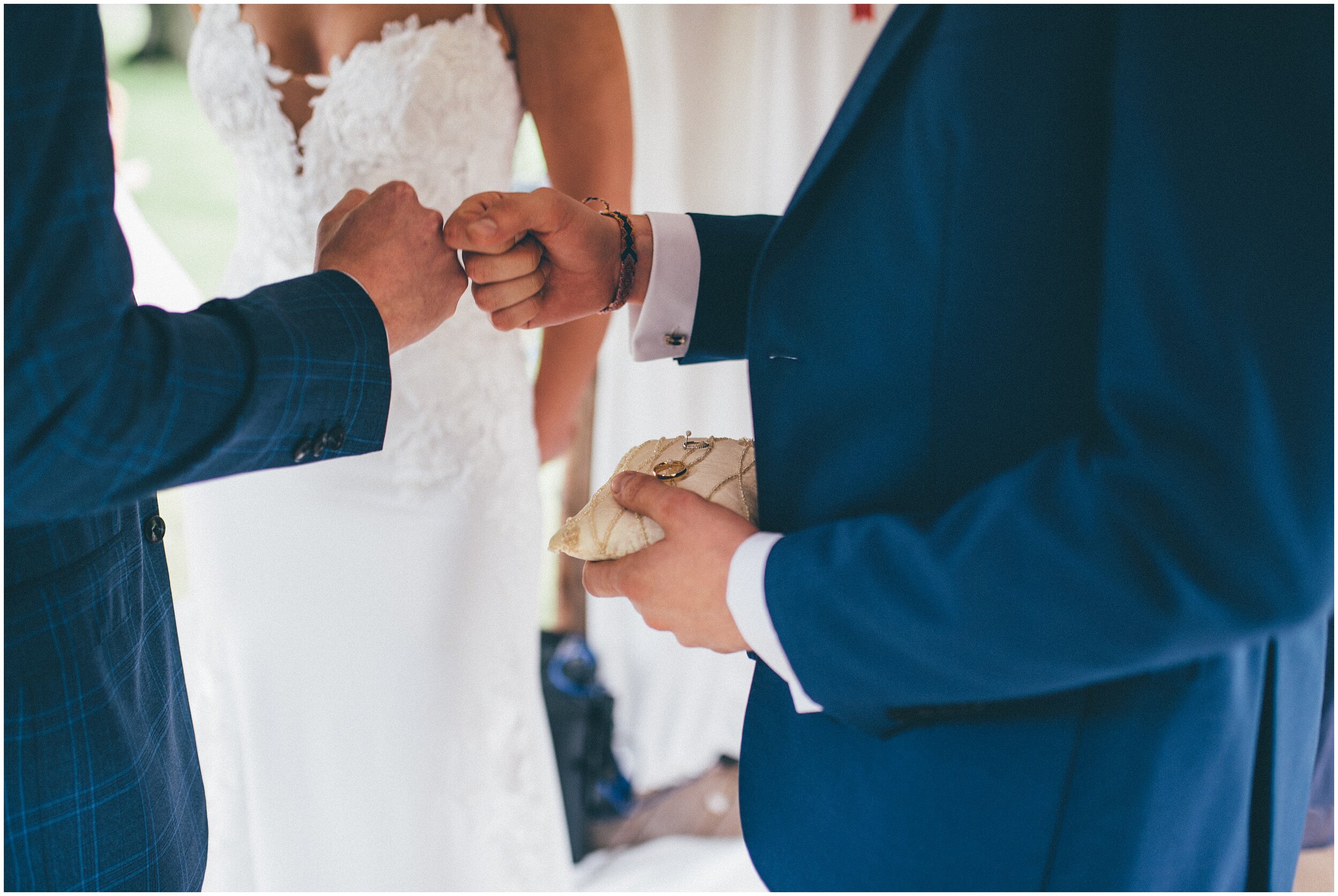 Groom fist bumps his best friend before exchanging rings with his bride.