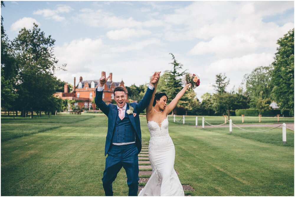 Newlyweds celebrate walking towards their wedding breakfast at Cheshire wedding venue.