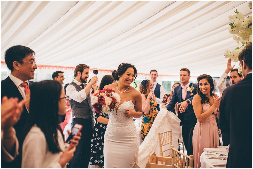 Guests celebrate bride and groom walking into their wedding breakfast at Cheshire wedding.