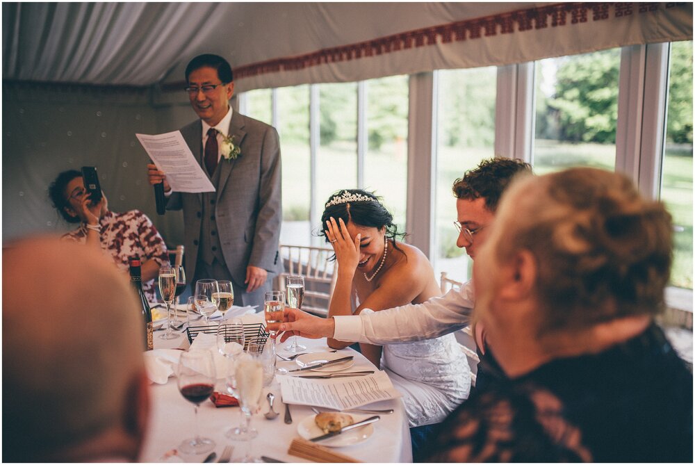 Bride has her head in her hands and is embarrassed during the Father of the bride wedding speech at Cheshire wedding venue.