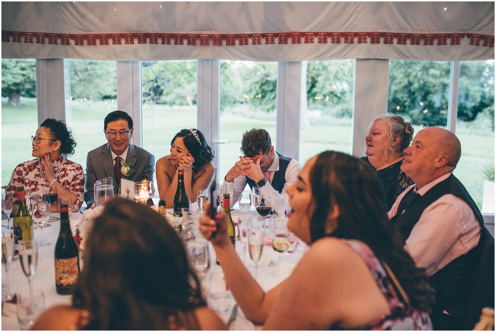 Bride and groom both have their head in their hands during best mans speech at Cheshire wedding venue.