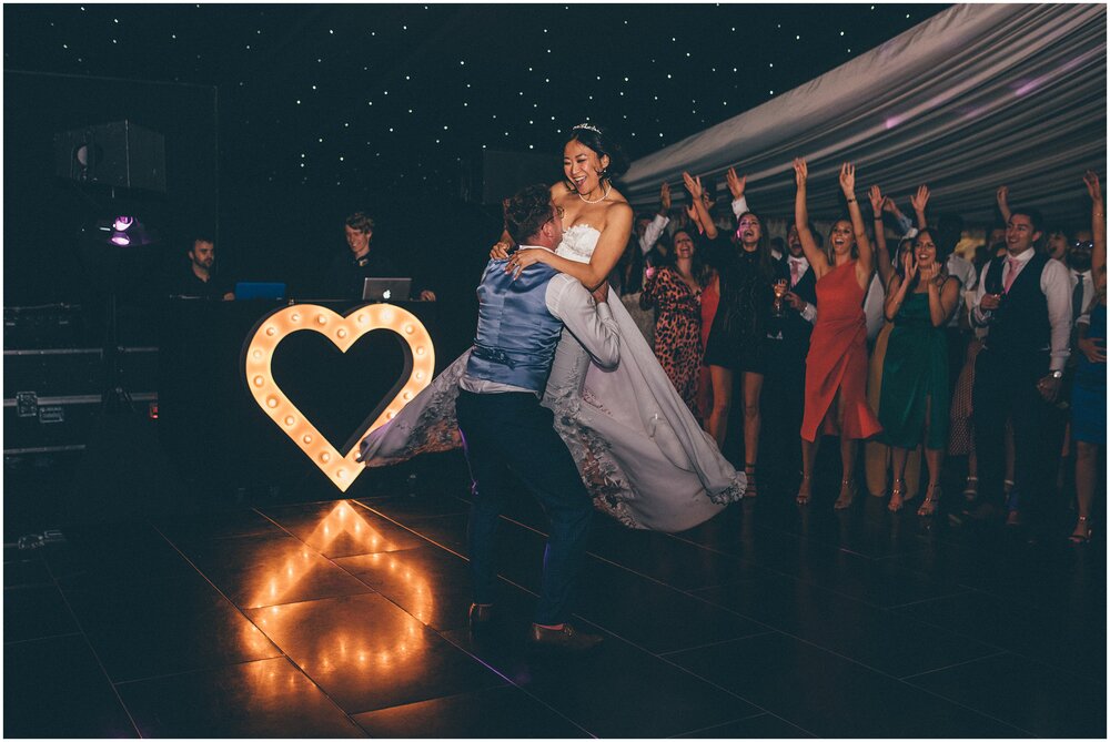 Bride is lifted by the groom during their First Dance at Cheshire wedding venue.