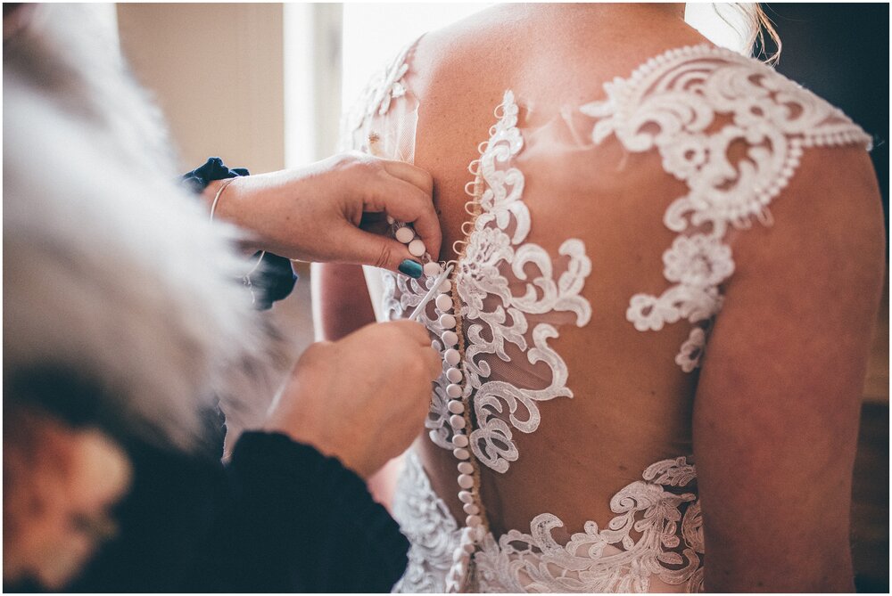 Bride's mum buttons bride into her lace Essence of Australia gown.