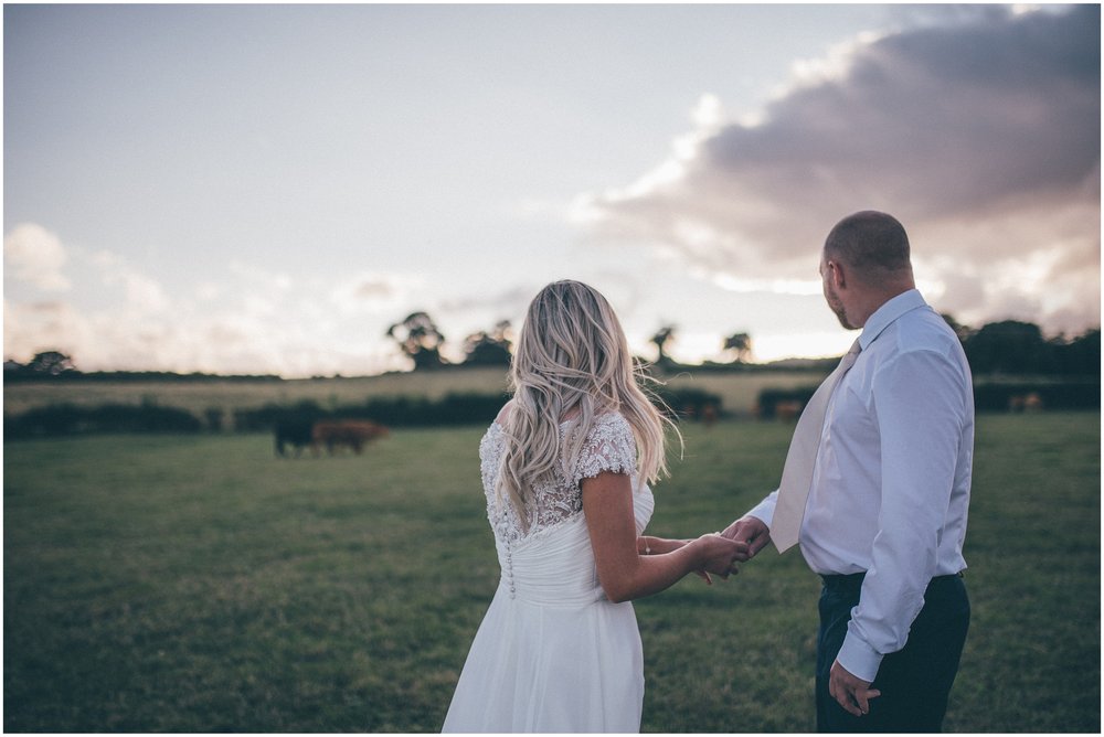 Bride and Groom walk through fields at Tower Hill Barns in North Wales