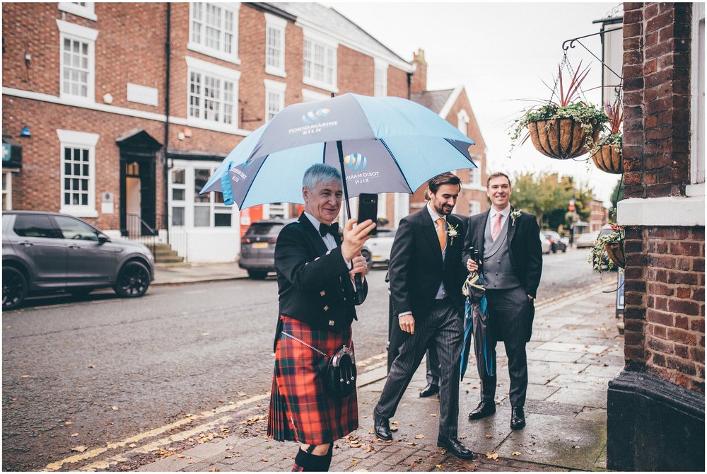 Groom's dad takes photographs of his son in Tarporley, Cheshire