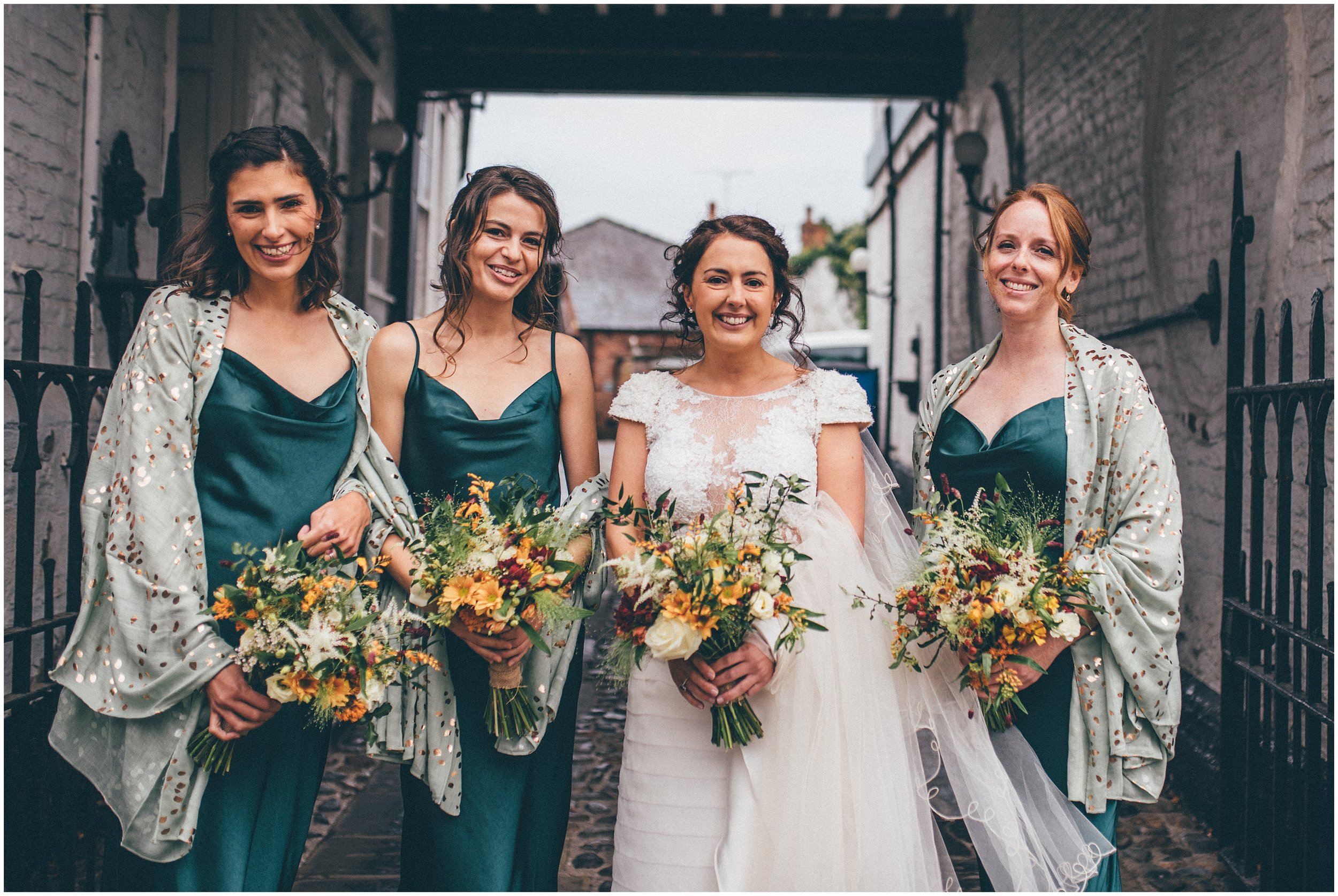 Bride and her bridesmaids stand together for wedding photographs before the wedding in Tarporley, Cheshire