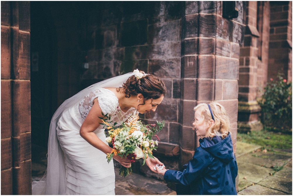 Little girl gives bride a good luck horseshoe at a wedding in Cheshire