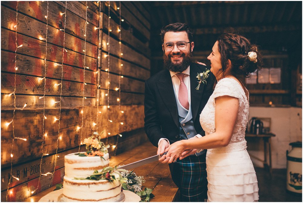 Bride and groom cut their wedding cake at Grange Barn wedding in Cheshire