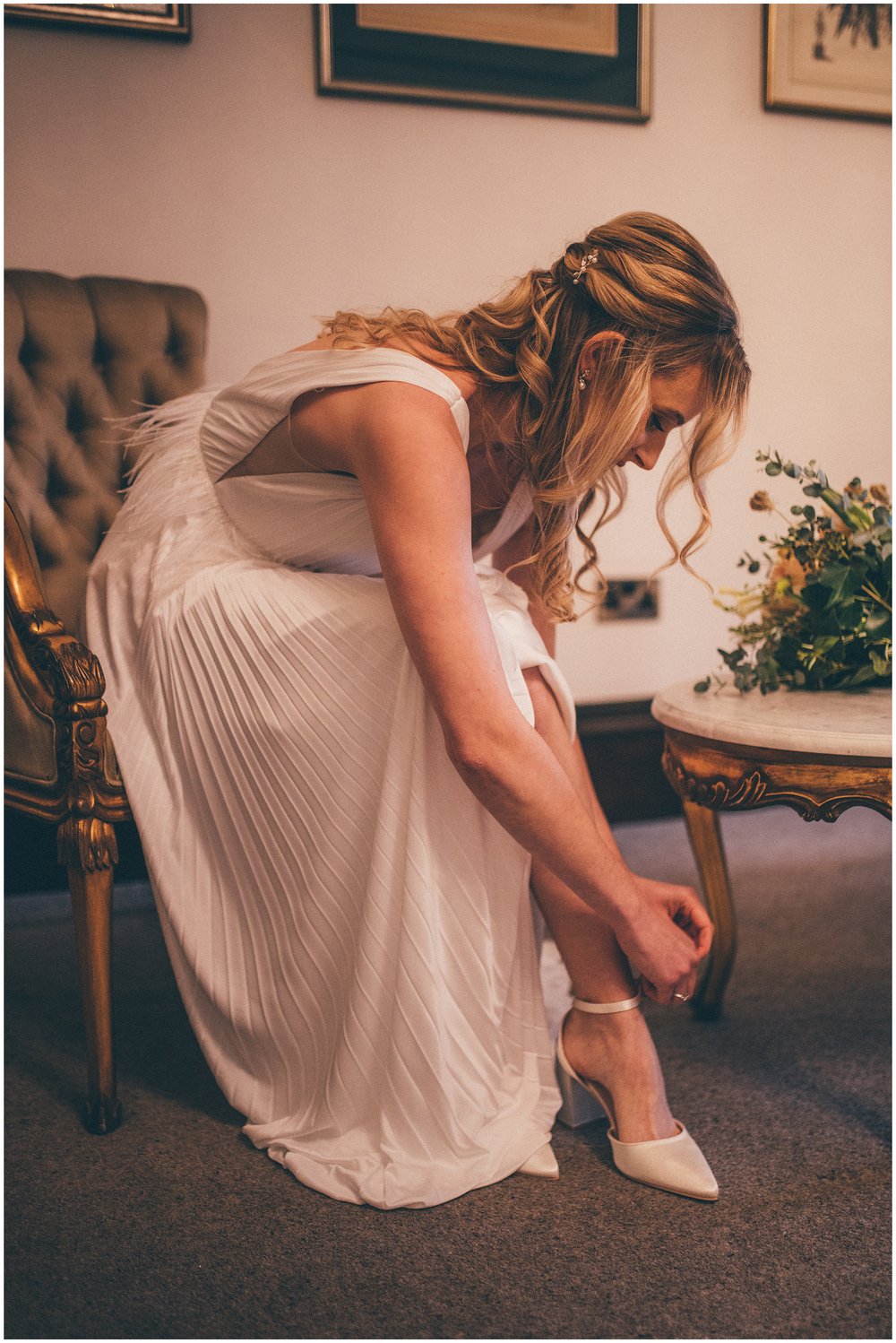 Bride puts on her shoes ahead of her Tyn Dwr Hall wedding