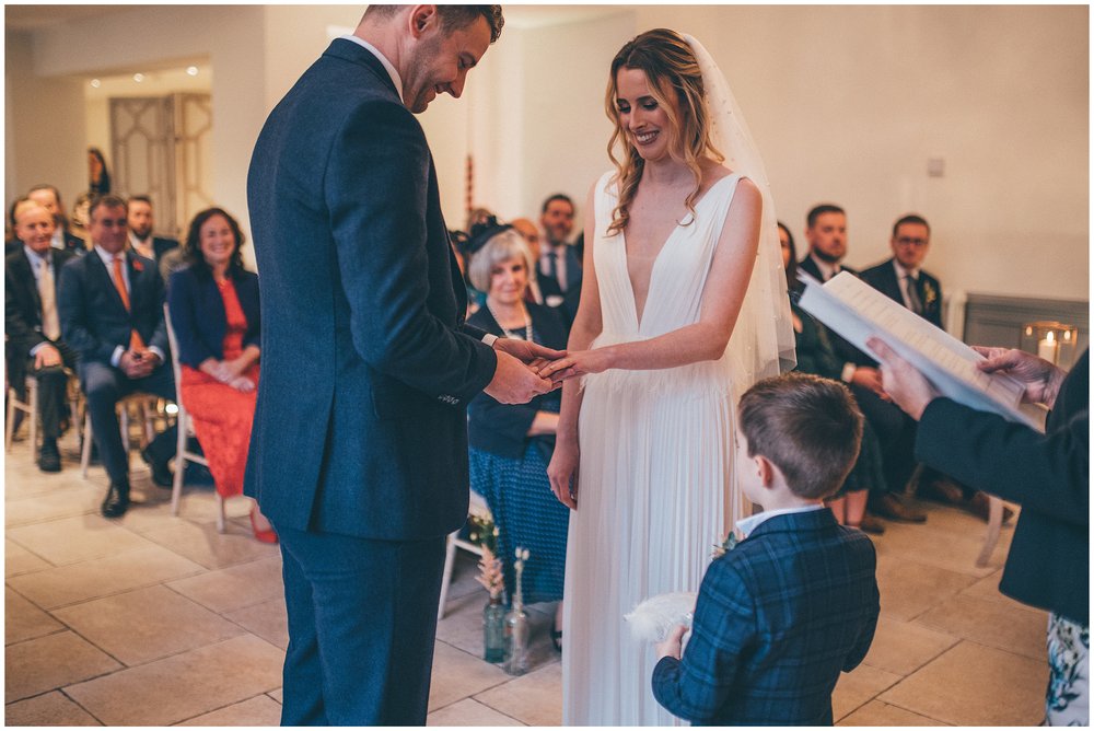 Ring bearer gives bride and groom their rings during the wedding ceremony at Tyn Dwr Hall