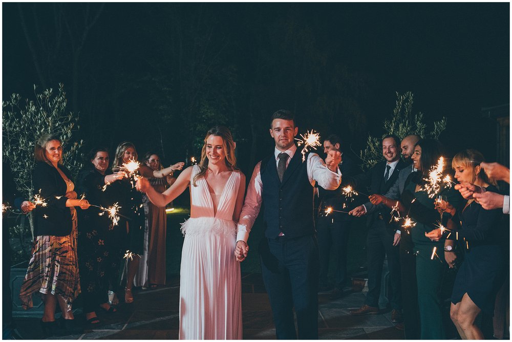 Newlyweds and their guests all play with sparklers during their wedding at Tyn Dwr Hall