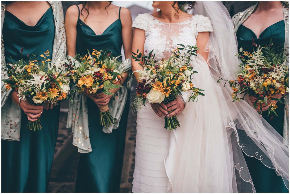 Bride and her bridesmaids hold their autumnal bouquets at Cheshire wedding in Tarporley