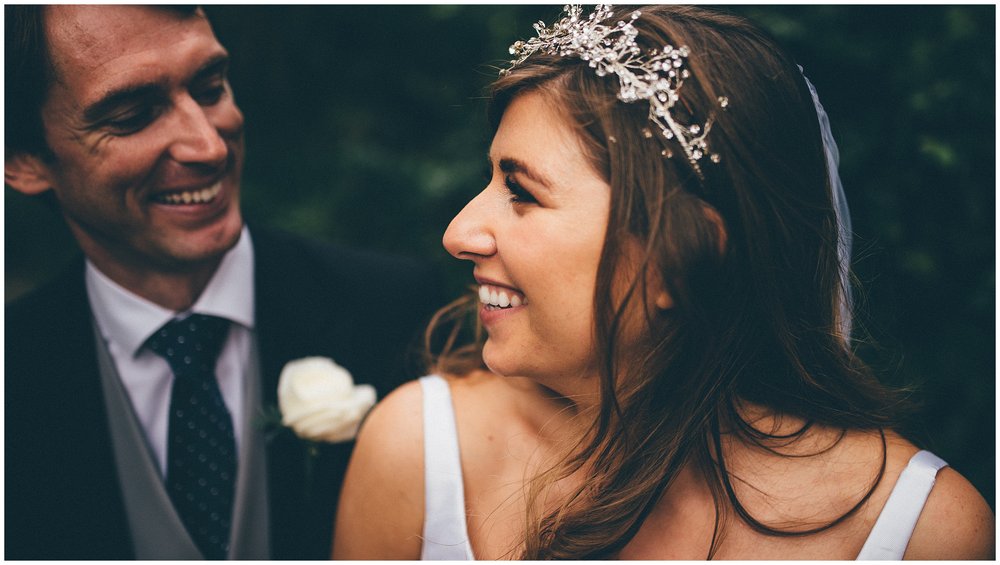 Bride and groom smile at each other at their Cheshire wedding at Thornton Manor