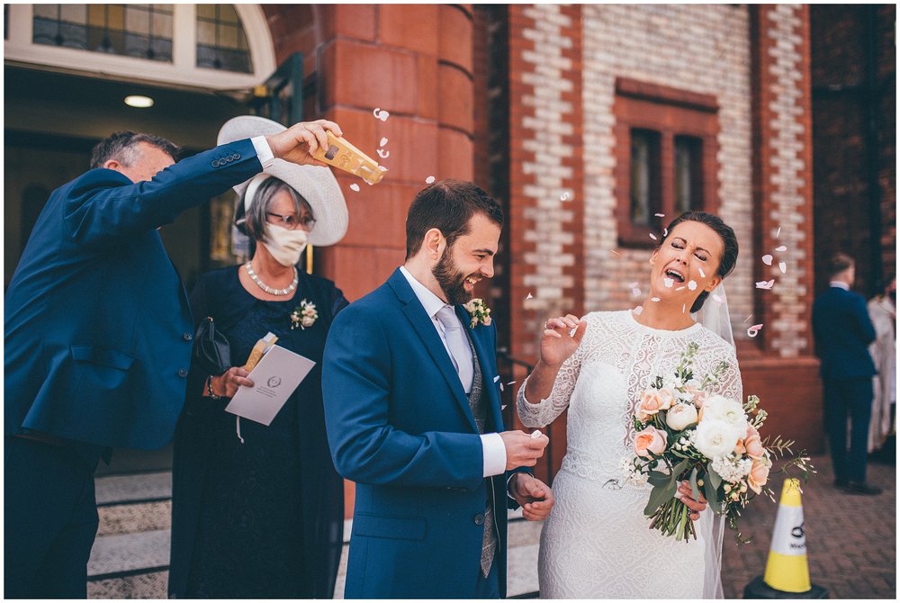 Bride gets surprised as a guest throws confetti in her face at a Manchester wedding