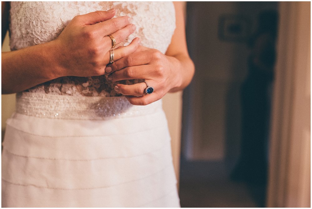 Bride fiddles with her rings ahead of her wedding, wearing a beautiful blue sapphire engagement ring