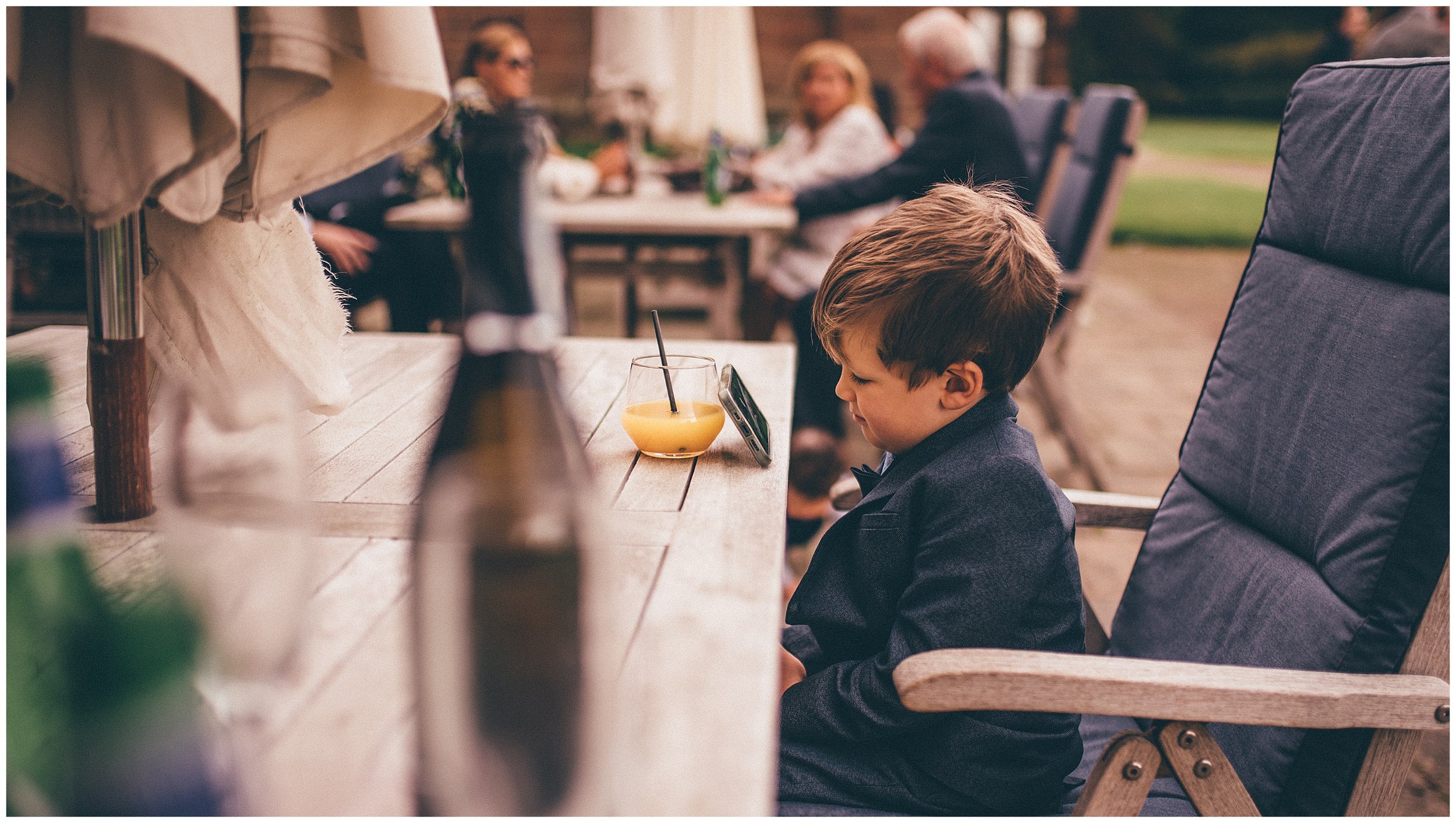 Little boy watches a tv show on a phone at wirral wedding