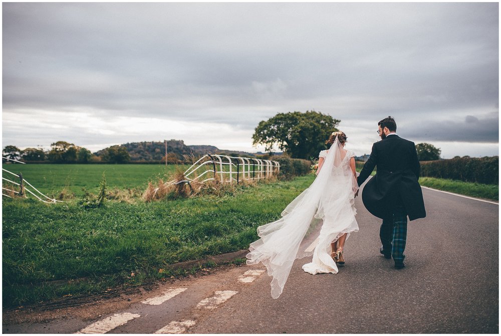 Bride and groom walks down a country lane together in Cheshire