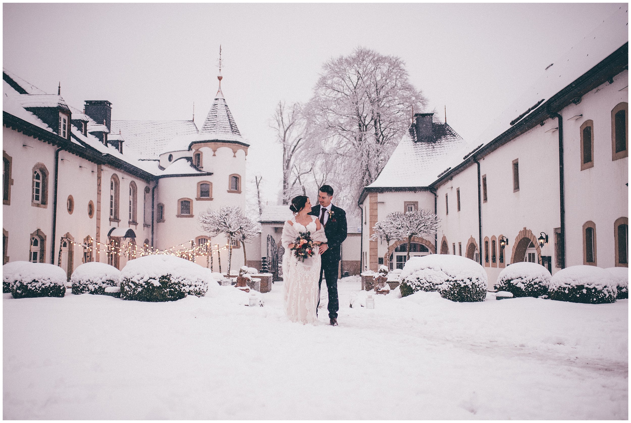 Bride and groom gaze lovingly at each other in the snow at Chateau D'Urspelt in Luxembourg