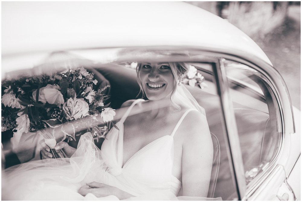 Bride smiles out of her wedding car ahead of her Cheshire wedding