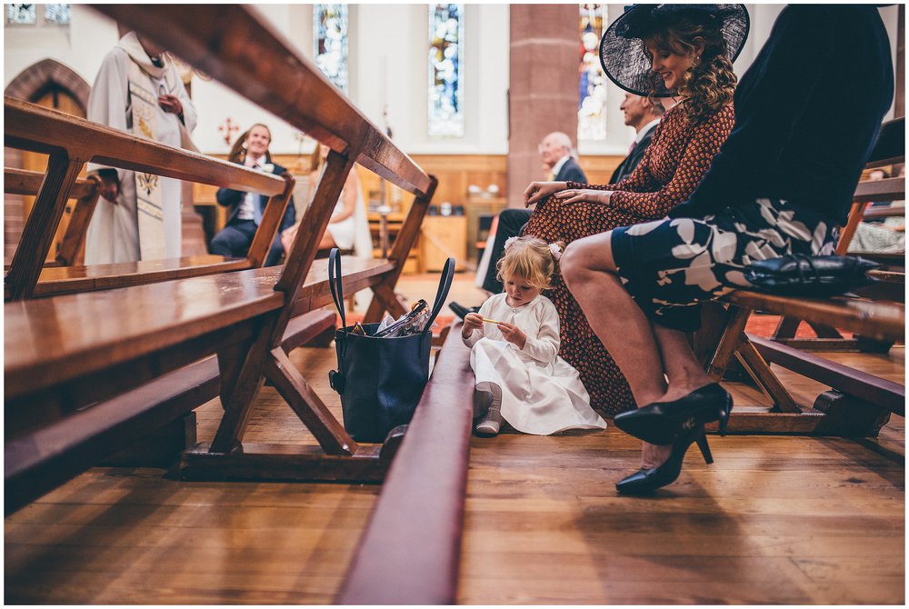 Little girls sits on the floor in Chester city centre church during the wedding