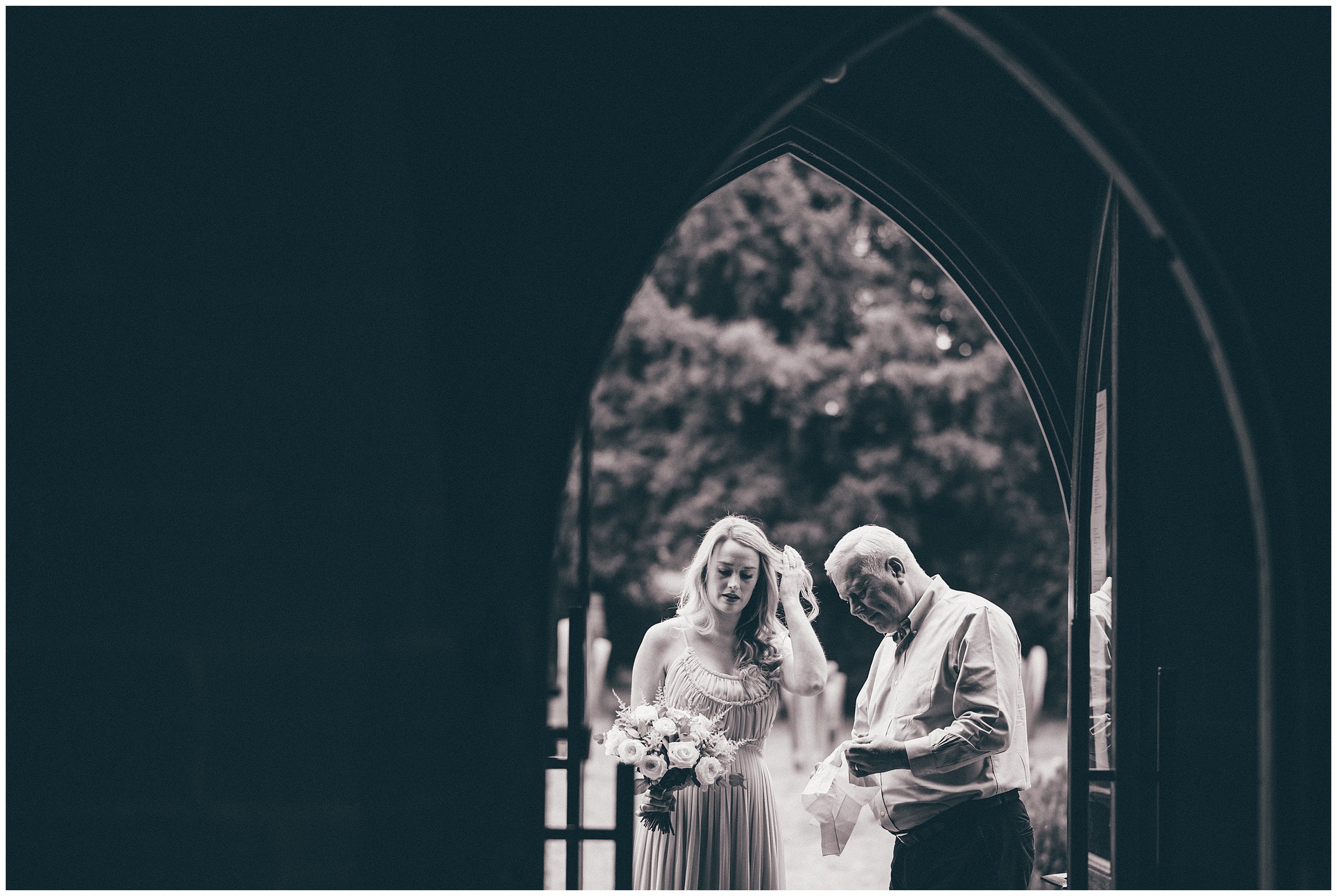 Bride and her dad wait at the front of the church in the doorway in Chester