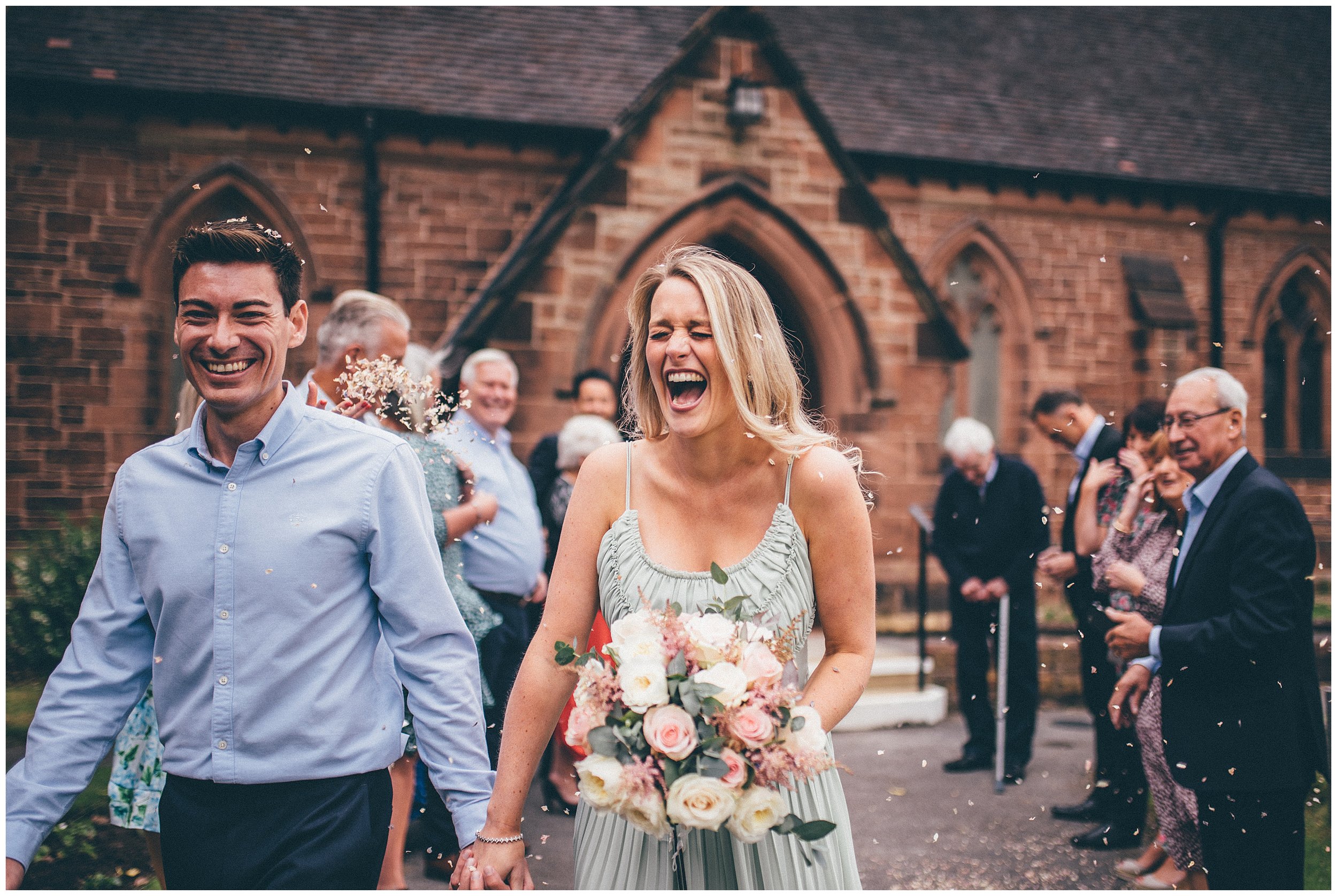 Bride beams after guests have thrown confetti over them during their covid wedding