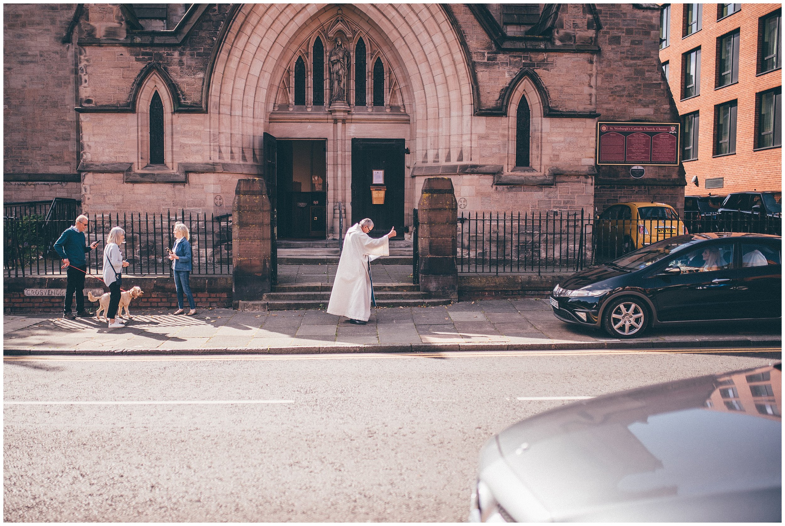 Vicar does a Thumbs up to a car parking at the church