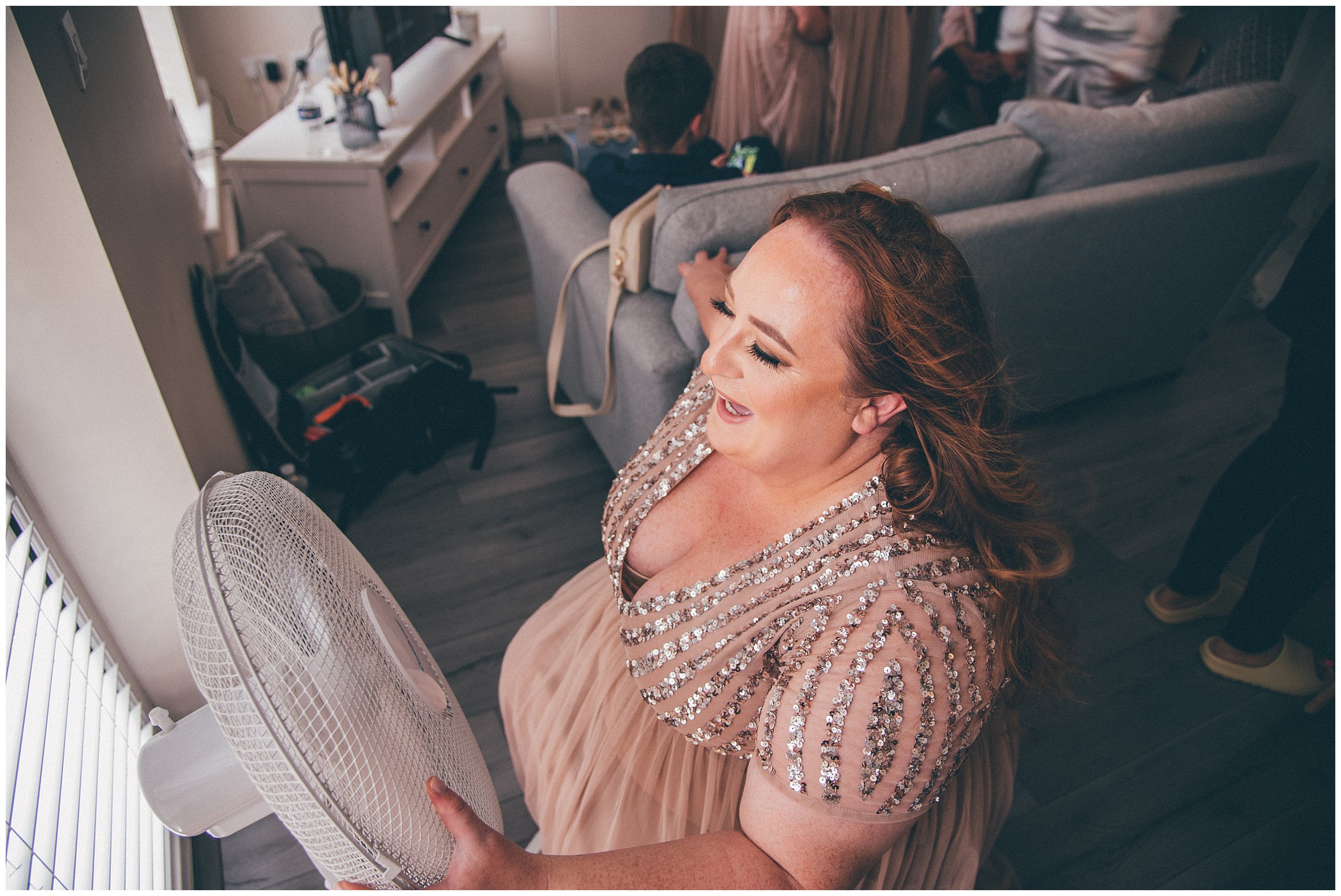 Bridesmaid sits in front of a fan in summer wedding heatwave